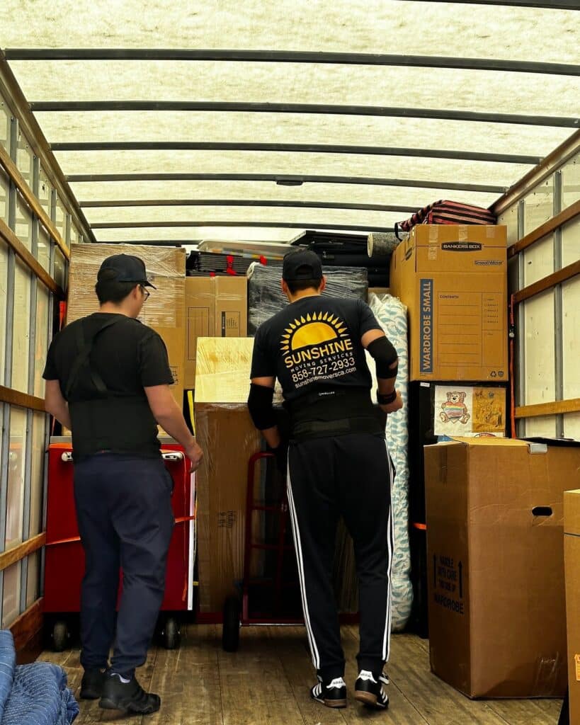 Movers loading boxes inside a moving truck