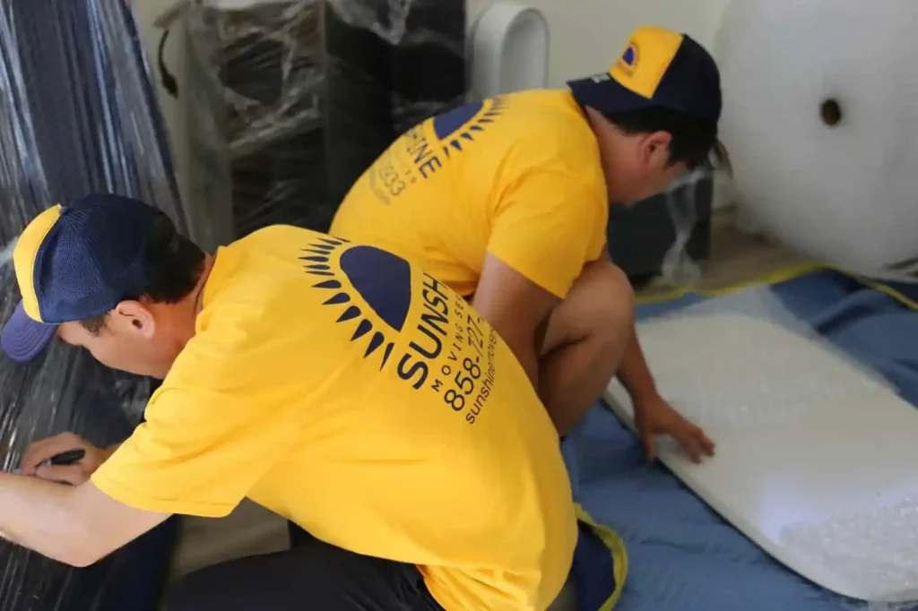 Movers wrapping a mattress during a move